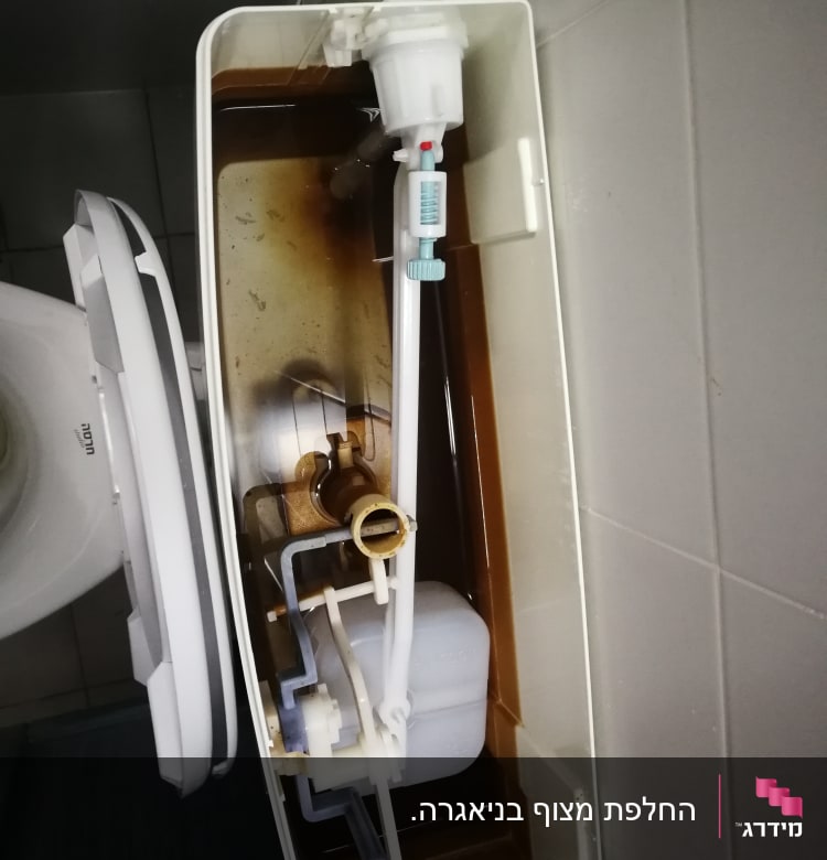 מיכל הדחה פתוח עם מנגנון פנימי חלוד